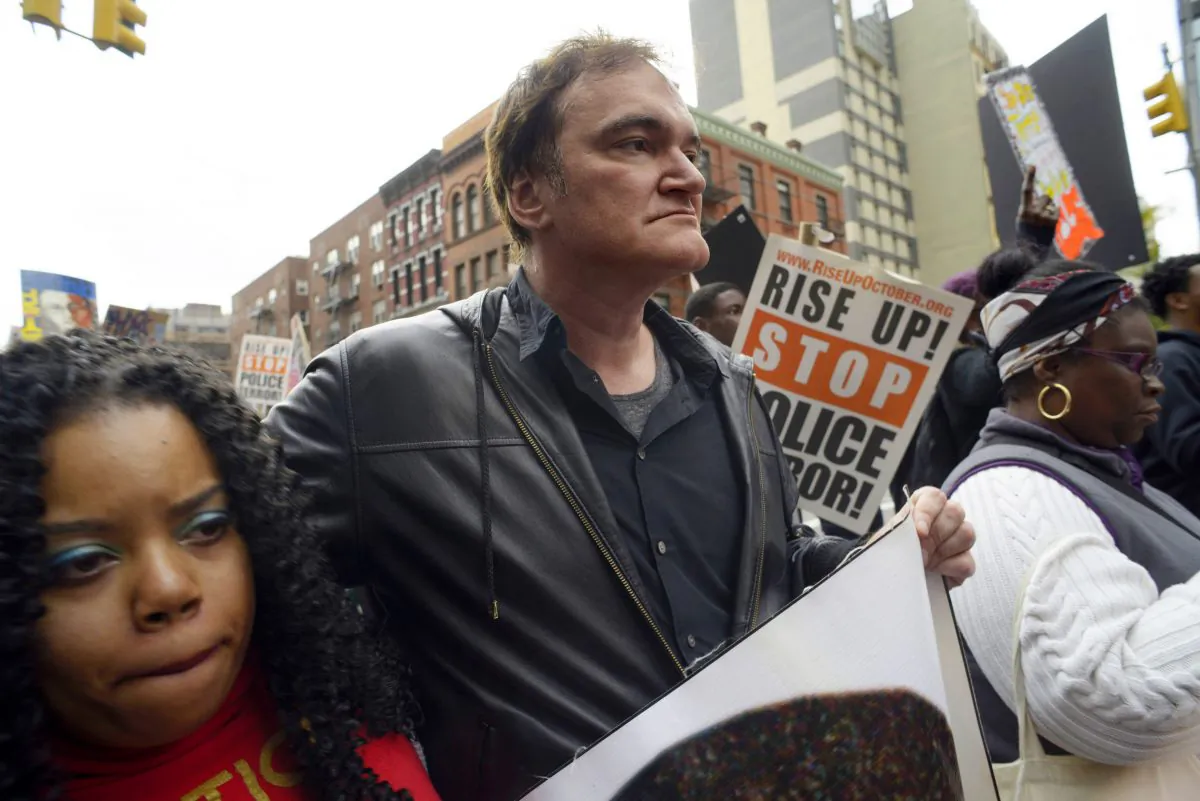 Director Quentin Tarantino (C) participates in a rally to protest against police brutality in New York on Oct. 24, 2015. Calls by police groups to boycott Quentin Tarantino's "The Hateful Eight" are putting pressure on one of Decembers most anticipated releases and inserting one of Hollywoods top directors into a pitched cultural battle. In recent days, a growing number of police groups have called for the boycott of the upcoming Weinstein Co. release. (AP Photo/Patrick Sison)