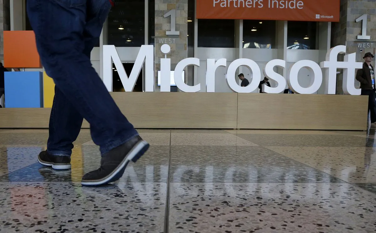 A man walks past a Microsoft sign set up for the Microsoft BUILD conference at Moscone Center in San Francisco, on April 28, 2015. Starting next year, Microsoft will cut the free space it offers through its OneDrive service to 5 gigabytes, down from 15 gigabytes now. Microsoft says the new allotment is enough for about 6,600 Office documents or 1,600 photos. (AP Photo/Jeff Chiu)