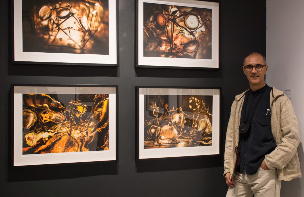 Romanian-Canadian artist Eugen-Florin Zamfirescu poses with some of his works on display at the TeodoraART Gallery in Toronto. (Elena Dumitru)
