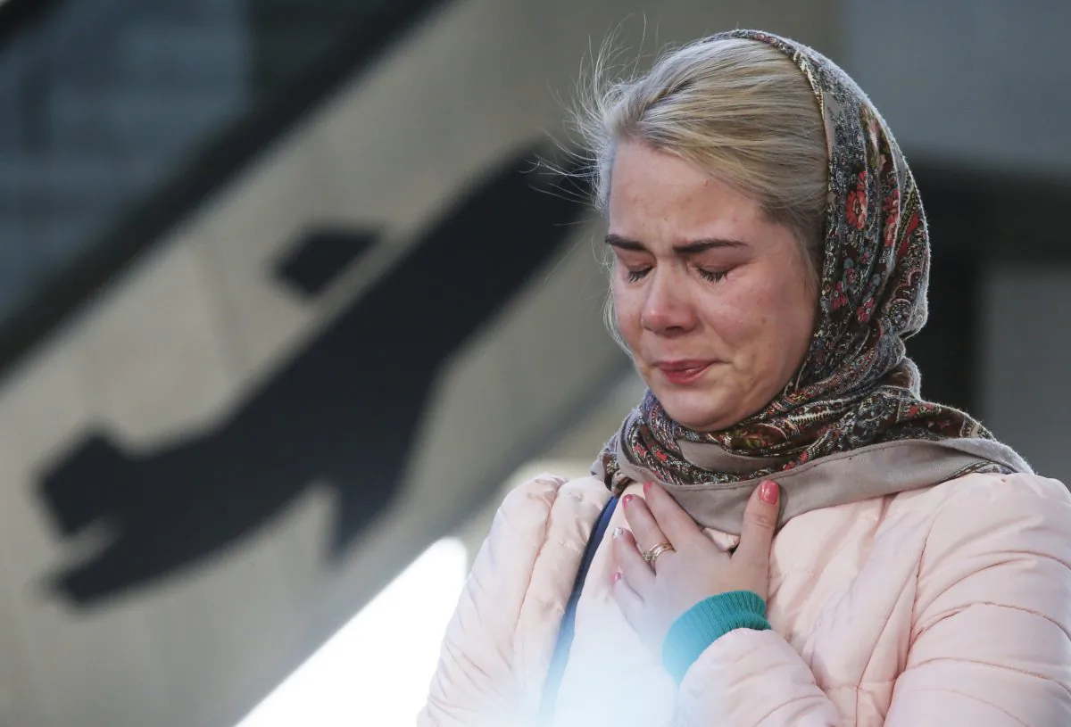 A woman reacts at an entrance of Pulkovo airport during a day of national mourning for the victims of the plane crash, outside St. Petersburg, Russia, Tuesday, Nov. 3, 2015. (AP Photo/Dmitry Lovetsky)