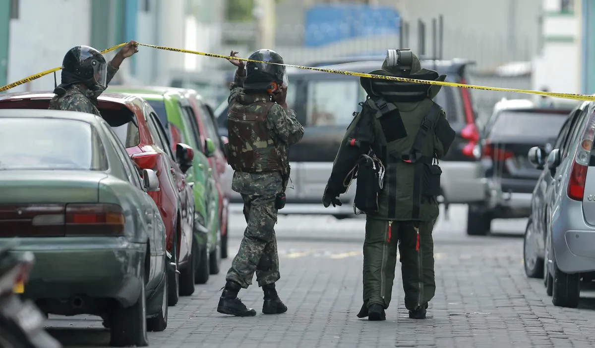 Police and Maldives National Defense Force (MNDF) personnel cordon off an area suspecting an explosive inside the engine compartment of a parked broken car in Male, Maldives, Wednesday, Nov. 4, 2015. The same was later confirmed to be a hoax call.The president of the Maldives declared a state of emergency on Wednesday that sharply curtails key rights of citizens for 30 days following an explosion on his speedboat and the discoveries of a homemade bomb near his residence and a weapons cache. (AP Photo/Mohamed Sharuhaan)