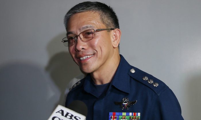 Spokesman Col. Restituto Padilla talks briefly with the media about the latest video of two kidnapped Canadians, a Norwegian, and a Filipina woman as he arrives for a meeting with Foreign Affairs officials in Manila Nov. 4, 2015. (AP Photo/Bullit Marquez)