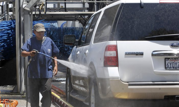 FILE - In this June 24, 2015, file photo, a worker washes a car at Bob's Car Wash in Roseville, Calif. The Labor Department releases third-quarter productivity data on Thursday, Nov. 5, 2015. (AP Photo/Rich Pedroncelli, File)