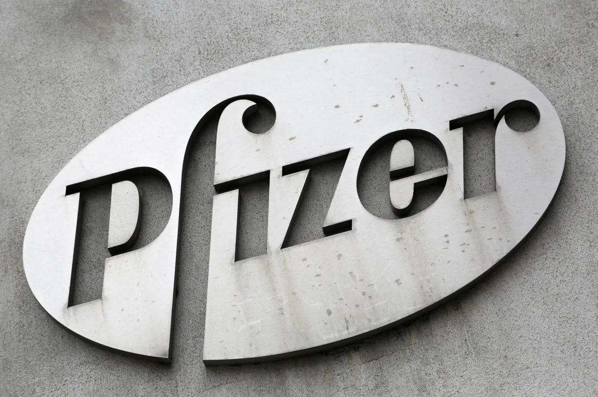 FILE - In this May 4, 2014, file photo, the Pfizer logo is displayed on the exterior of a former Pfizer factory in the Brooklyn borough of New York. Pfizer, the biggest U.S.-based drugmaker, is increasing its financial assistance to patients by doubling the allowable income level for people to receive Pfizer medicines for free. (AP Photo/Mark Lennihan, File)
