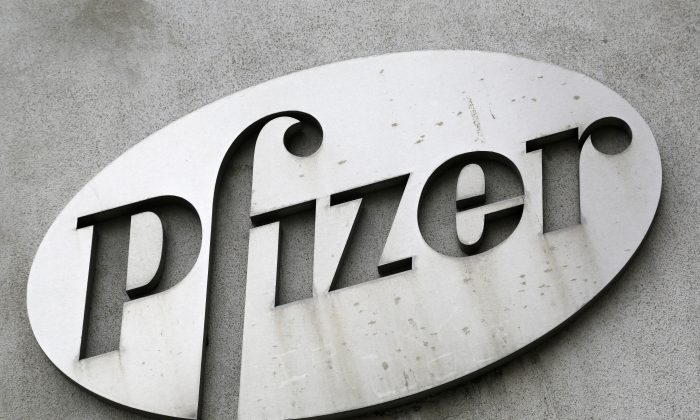 FILE - In this May 4, 2014, file photo, the Pfizer logo is displayed on the exterior of a former Pfizer factory in the Brooklyn borough of New York. Pfizer, the biggest U.S.-based drugmaker, is increasing its financial assistance to patients by doubling the allowable income level for people to receive Pfizer medicines for free. (AP Photo/Mark Lennihan, File)