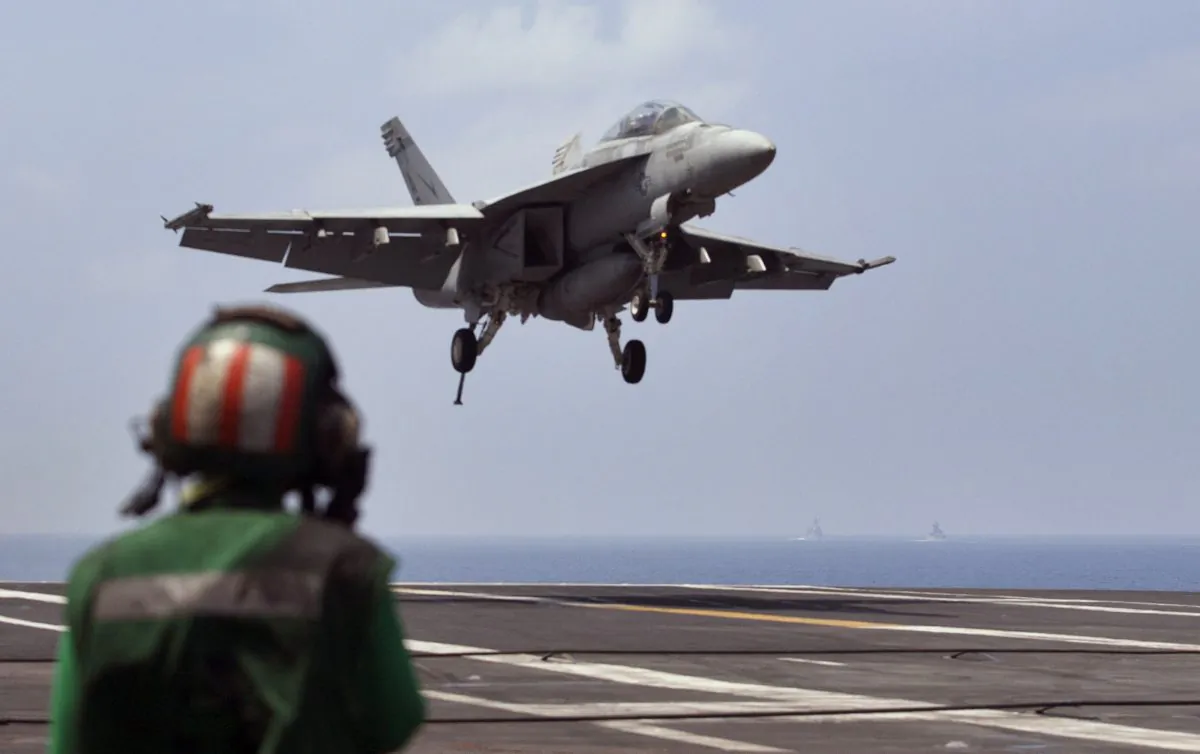 A U.S. Navy fighter jet approaches to land on the aircraft carrier USS Theodore Roosevelt (CVN 71), a missile cruiser and a nuclear-powered submarine during Exercise Malabar 2015, some 152 miles off eastern coast of Chennai, India, Saturday, Oct. 17, 2015. Naval warships, aircraft carriers and submarines from the U.S., India and Japan steamed into the Bay of Bengal on Saturday as they took part in joint military exercises off India's east coast, signaling the growing strategic ties among the three countries as they face up to a rising China. (AP Photo/Arun Sankar K.)