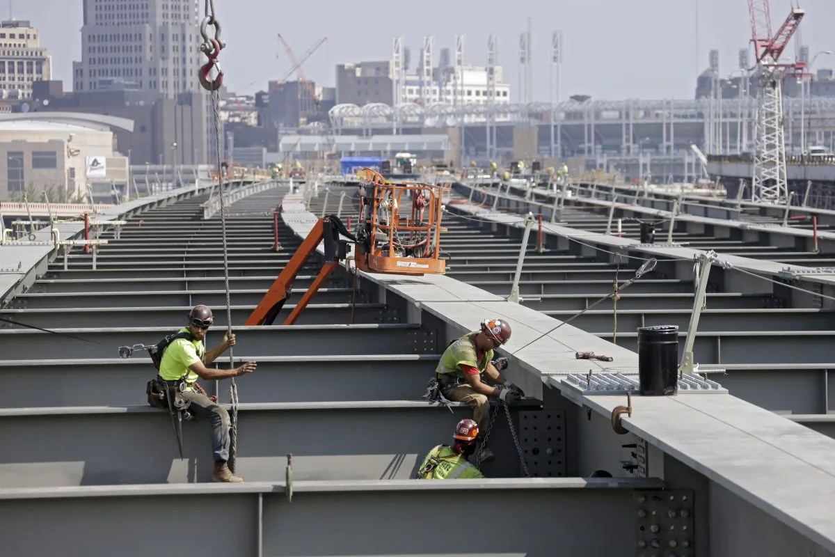 Ironworkers secure a cross member on a highway bridge under construction in Cleveland in 2013. The House has voted to continue transportation programs for six years with no significant increase in spending. That’s despite warnings that the nation’s roads, bridges and transit systems are falling apart.  (AP Photo/Mark Duncan)