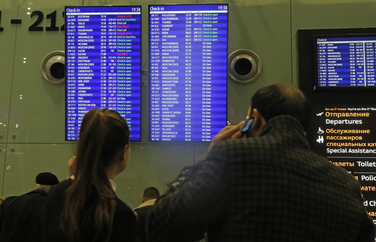 People look at an indicator board displaying flight information, at Pulkovo airport outside St.Petersburg, Russia, Friday, Nov. 6, 2015. Russia announced Friday it will suspend all flights to Egypt until security is improved at its airports, the first sign of wariness from Moscow after days of resisting British and American warnings that a bomb planted by the Islamic State group may have brought down a Russian plane in the Sinai Peninsula last week. (AP Photo/Dmitry Lovetsky)