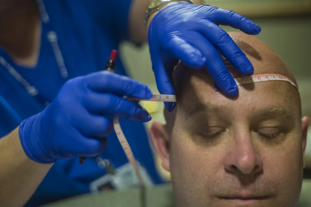 Registered sleep technician Elaine Sheely measures Daniel Gullickson's head for wire placement in Hanover Hospital's Sleep Lab in Hanover, Pa., on Sept. 1, 2015. (Clare Becker/The Evening Sun via AP)