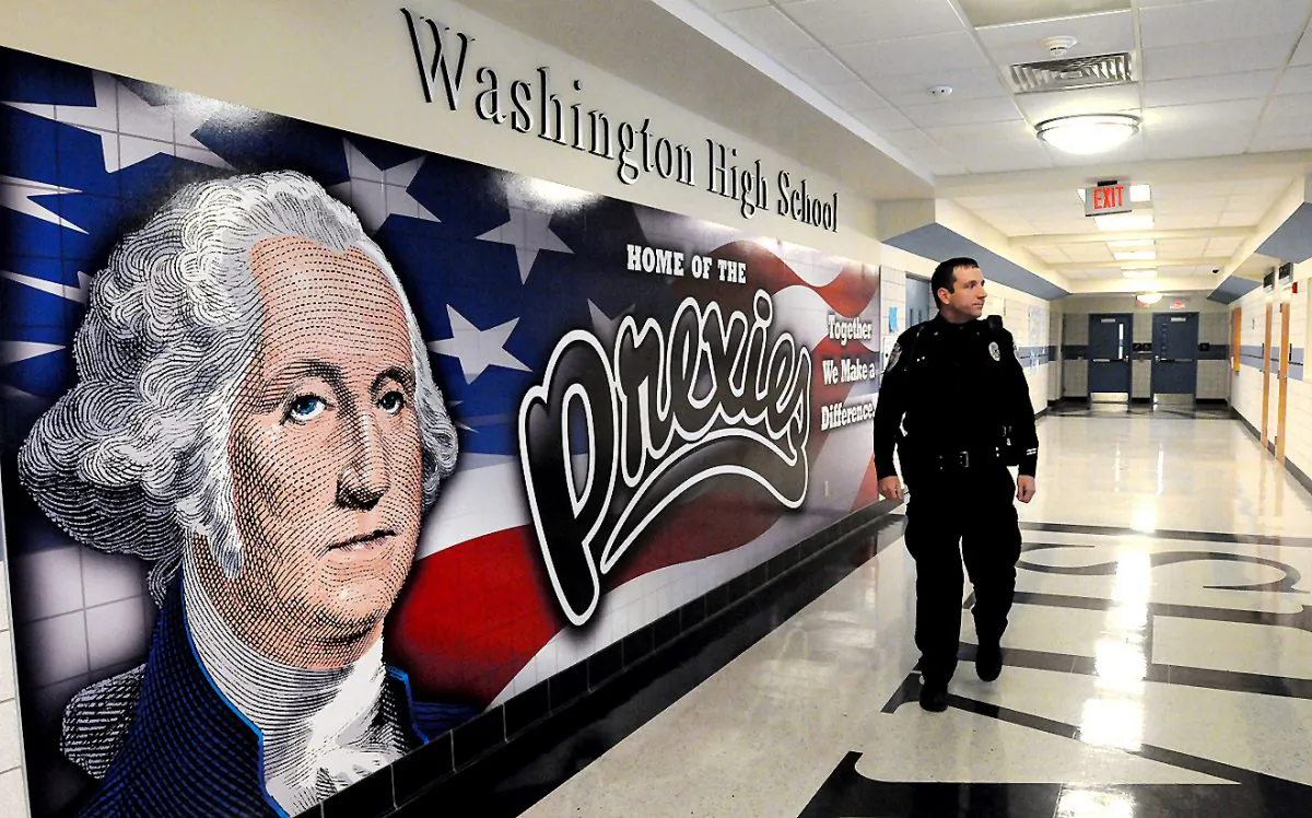 Washington police officer Todd Foreman—a Washington High School Resource officer—walks the hallways at school at part of his duties in Washington, Pa. Foreman, a city patrolman and detective who started at the district in 2004, says that forging relationships with students helps avoid or de-escalate potential problems. (Jim McNutt/Observer-Reporter via AP)
