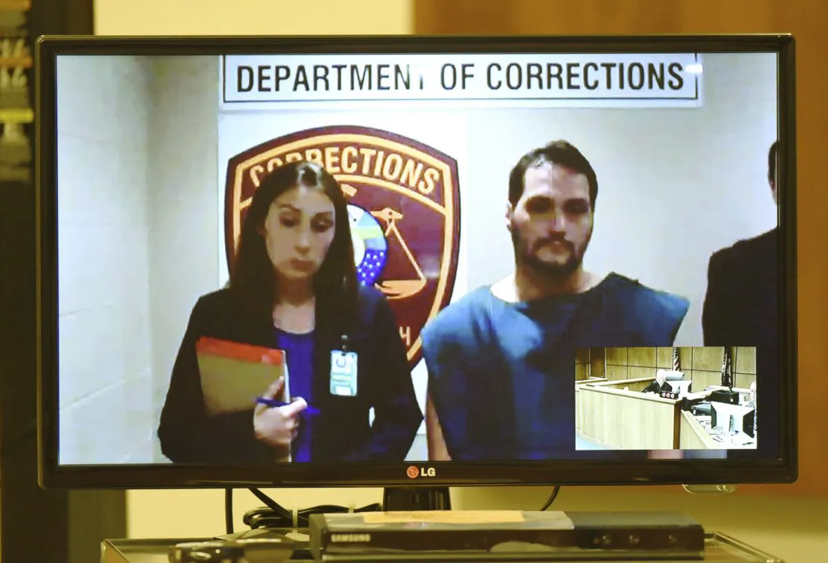 Matthew Dion is arraigned via video on double-murder charges at Manchester District Court in Manchester, N.H., on June 12, 2015. Public Defender Aileen O'Connell is pictured at left. All but one of New Hampshire’s district courtrooms are wired for video arraignments of criminal defendants from local jails to enhance security and cut transportation costs. Some defense lawyers object, saying that depicting their clients in a jail setting and jumpsuit taints the presumption of innocence until proven guilty. (David Lane/The Union Leader via AP)