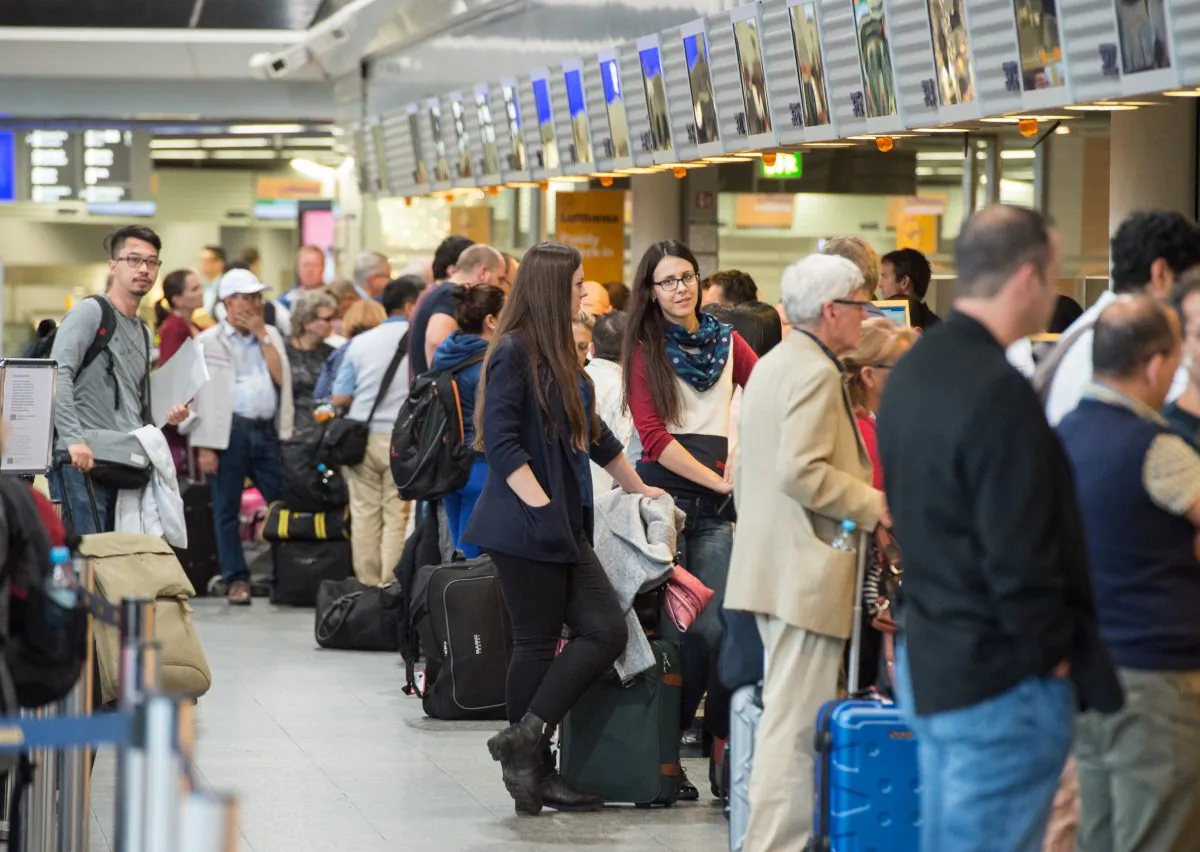 Passengers queue in front of Lufthansa counters at the airport in Frankfurt, Germany, on Nov. 7, 2015. (Boris Roessler/DPA via AP)