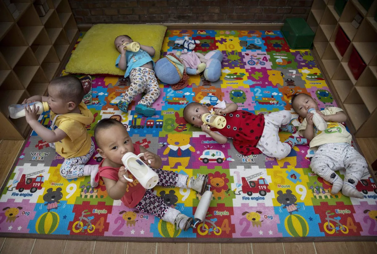 Young orphaned Chinese children drink milk from bottles at a foster care center on April 2, 2014 in Beijing. (Kevin Frayer/Getty Images)