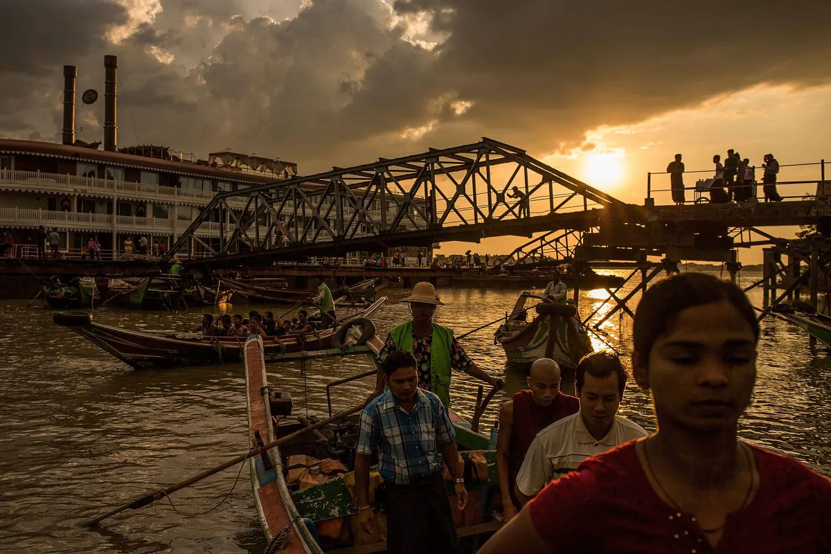 Sun shines in the distance as people ride boats and spend time at the pier on boats and swimming ahead of the landmark Nov. 8 elections, in Yangon, Burma, on Nov. 7, 2015. (Lam Yik Fei/Getty Images)