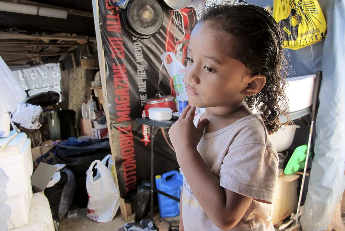 Keioleen Helly, 3, stands inside her family's sidewalk shelter in Honolulu on Oct. 7, 2015. The family was packing up belongings to take to a storage unit two days before the city planned to clear their block of the homeless encampment, hoping to get a ride to the storage unit from a volunteer. (AP Photo/Cathy Bussewitz)