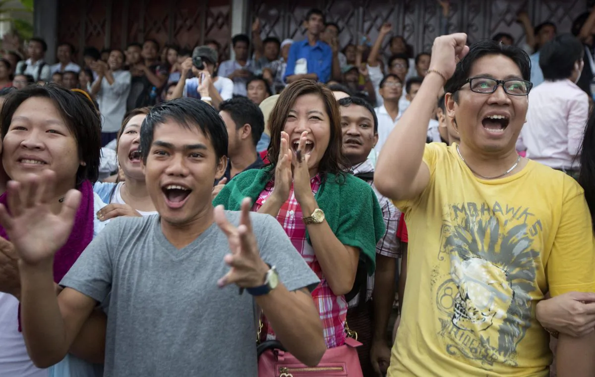 Supporters of Burma's National League for Democracy party cheer as they watch early voting results posted on a giant screen outside the NLD headquarters in Yangon, Burma, Sunday, Nov. 8, 2015. With tremendous excitement and hope, millions of citizens voted Sunday in Burma's historic general election that will test whether the military's long-standing grip on power can be loosened, with opposition leader Aung San Suu Kyi's party expected to secure an easy victory. (AP Photo/Mark Baker)