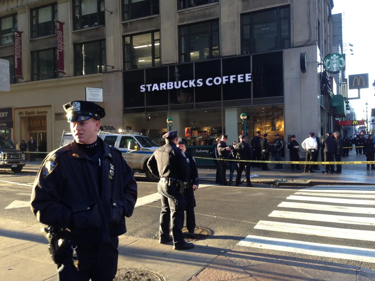 New York Police Department officers investigate a shooting at 35th Street and Eighth Avenue, Monday, Nov. 9, 2015, in New York. (AP Photo/Mark Lennihan)