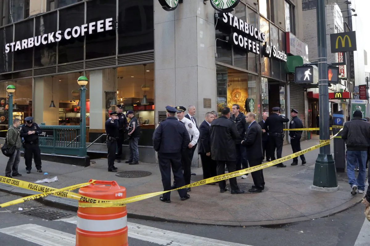 New York Police Department officers investigate a shooting near a subway station entrance at 35th Street and Eighth Avenue, Monday, Nov. 9, 2015, in New York. Authorities said three people have been shot, one fatally. No suspects were immediately arrested. (AP Photo/Mark Lennihan)