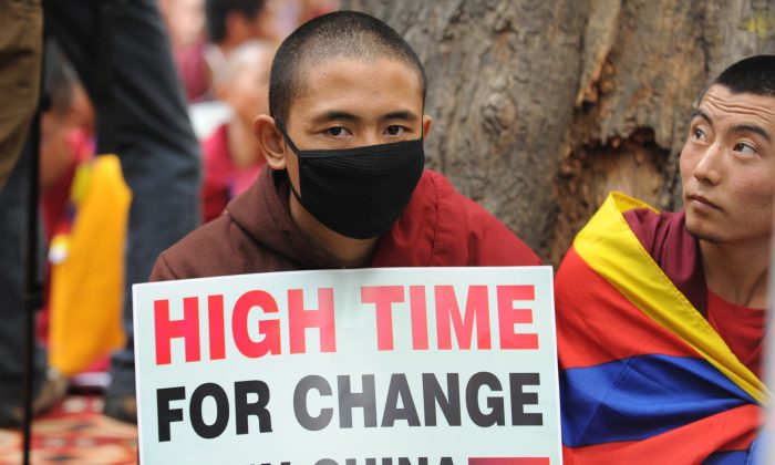 Tibetans monks hold placards during a protest rally in New Delhi on January 31, 2013. The Chinese regime has deployed a new surveillance system, which will make it more difficult for Tibetans to escape to Nepal. (Raveendran/AFP/Getty Images)