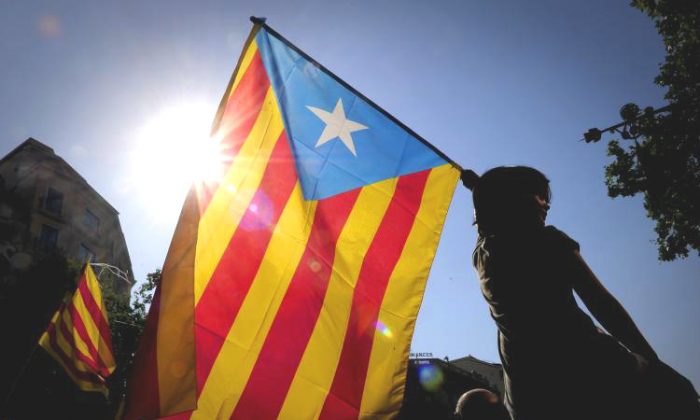 A woman holds the Catalan flag as hundreds of thousands of people marched on July 10 in Barcelona in support of the Catalan region's statute of autonomy. (Josep Lago/Getty Images)