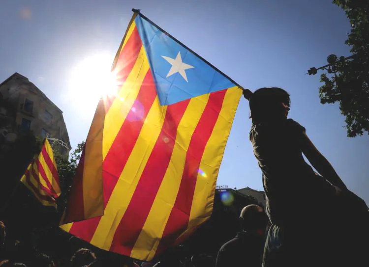 A woman holds the Catalan flag as hundreds of thousands of people marched on July 10 in Barcelona in support of the Catalan region's statute of autonomy. (Josep Lago/Getty Images)
