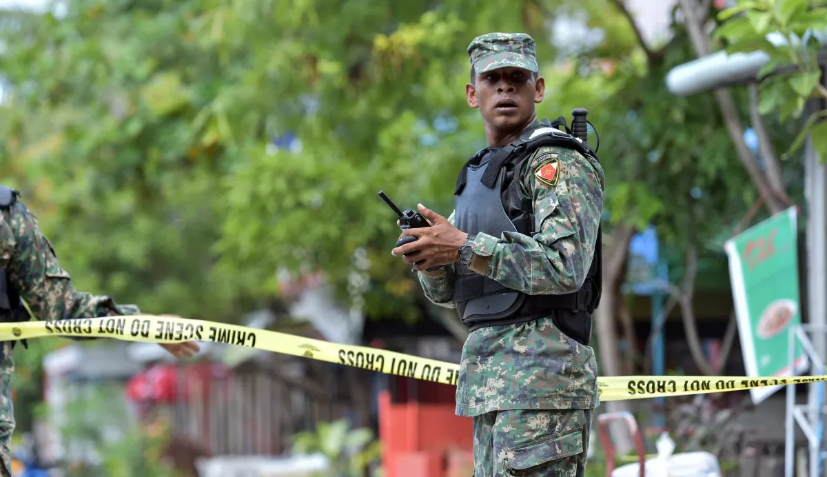 A Maldivian army officer stands guard at a cordoned off area after news of a suspected bomb being found near the harbor area, which turned out to be a false alarm, in Male, Maldives, Thursday, Nov. 5, 2015. (AP Photo/Mohamed Sharuhaan)