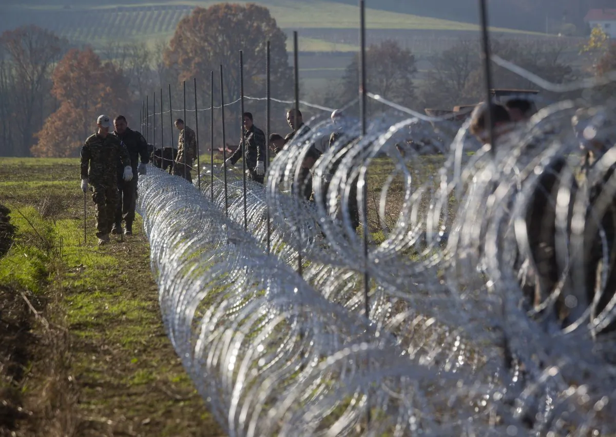 Slovenian soldiers erect a razor-wired fence on the Croatian border in Gibina, Slovenia, Wednesday, Nov. 11, 2015. (AP Photo/Darko Bandic)