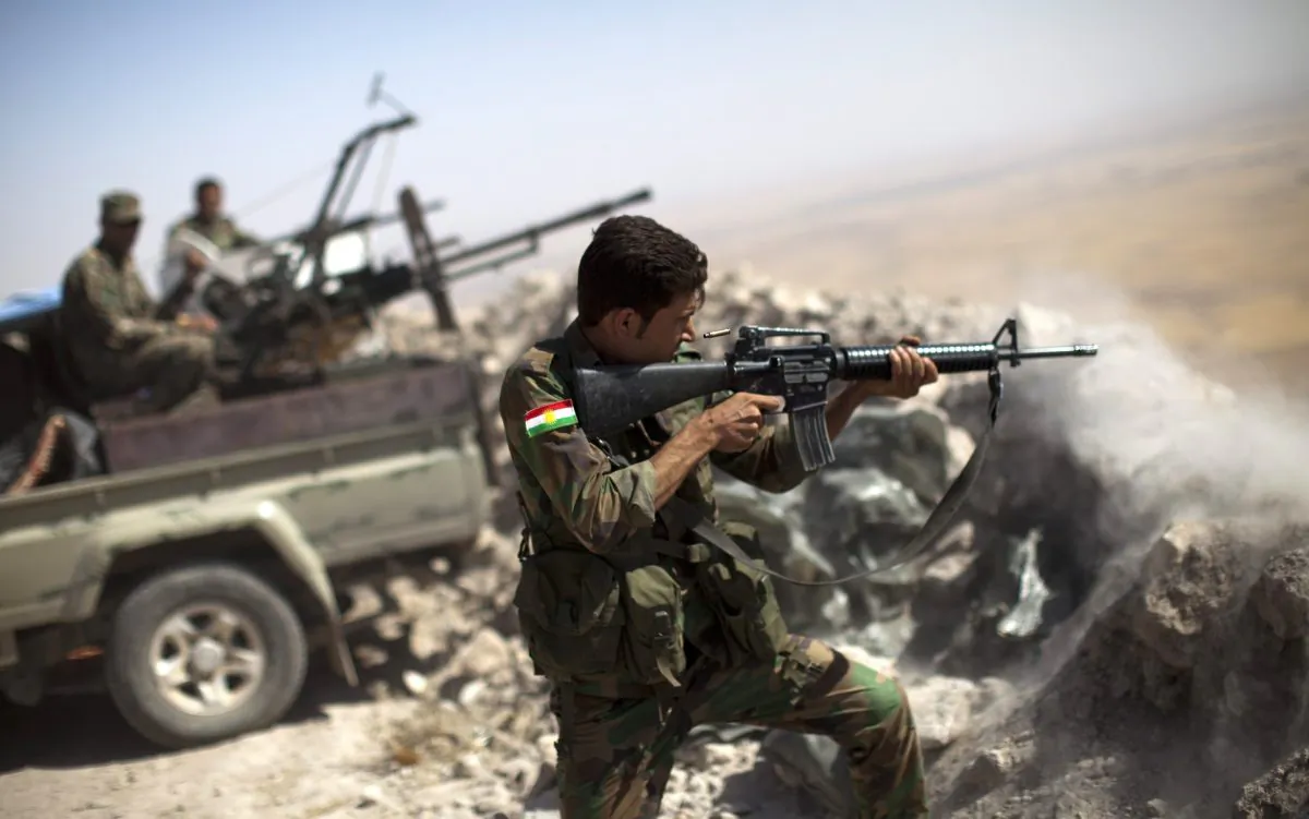 An Iraqi Kurdish Peshmerga fighter fires at ISIS militant positions, from his position on the top of Mount Zardak, a strategic point about 15.5 miles (25 km) east of Mosul on Sept. 9, 2014. (J.M. Lopez/AFP/Getty Images)