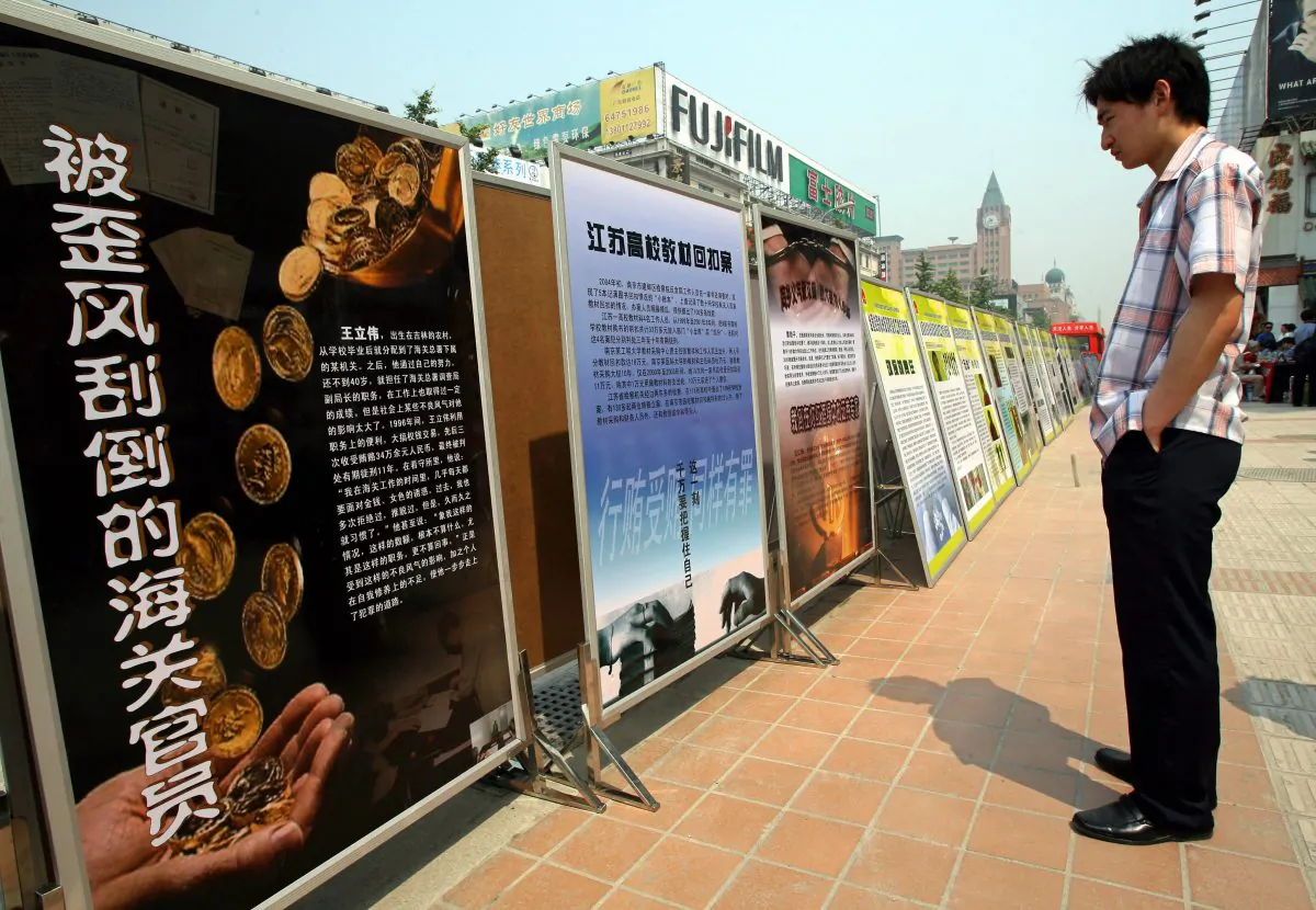 A Chinese man looks at anti-corruption billboards on display in Central Beijing, on June 11, 2007. (Teh Eng Koon/AFP/Getty Images)