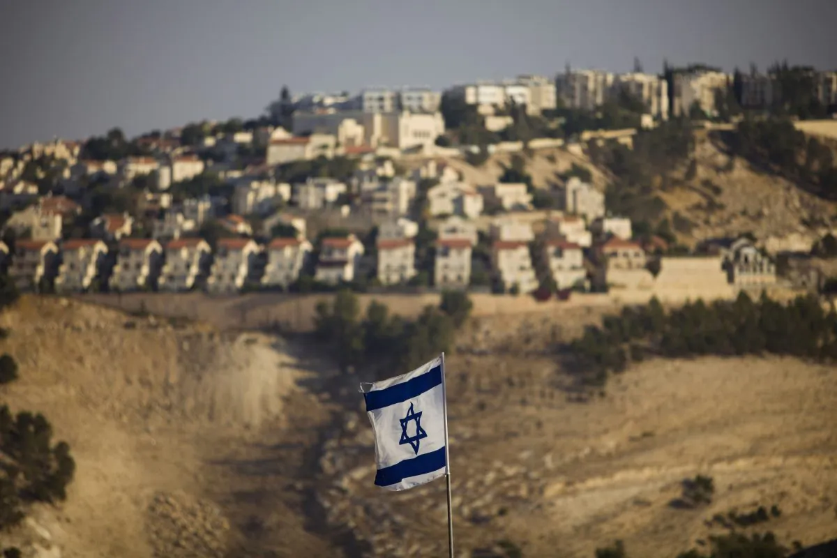 An Israeli flag is seen in front of the West Bank Jewish settlement of Maaleh Adumim on the outskirts of Jerusalem on Sept. 7, 2009. The European Union on Wednesday, Nov. 11, approved guidelines for its member states to specially label products made in West Bank settlements, a move that has already been criticized by Israel. (AP Photo/Bernat Armangue)