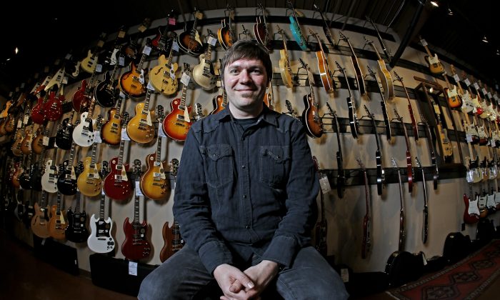 Brian Douglas is photographed at the Cream City Music store Wednesday, Nov. 11, 2015, in Brookfield, Wis. Cream City Music sells more than 1,800 items from guitar picks to vintage instruments on Reverb.com, a musical equipment marketplace. The retailer began selling on Reverb.com two years ago. Small retailers use high-tech innovations to build relationships with customers; they often can't compete with big chains on prices, so they aim at better, individualized service. (AP Photo/Morry Gash)