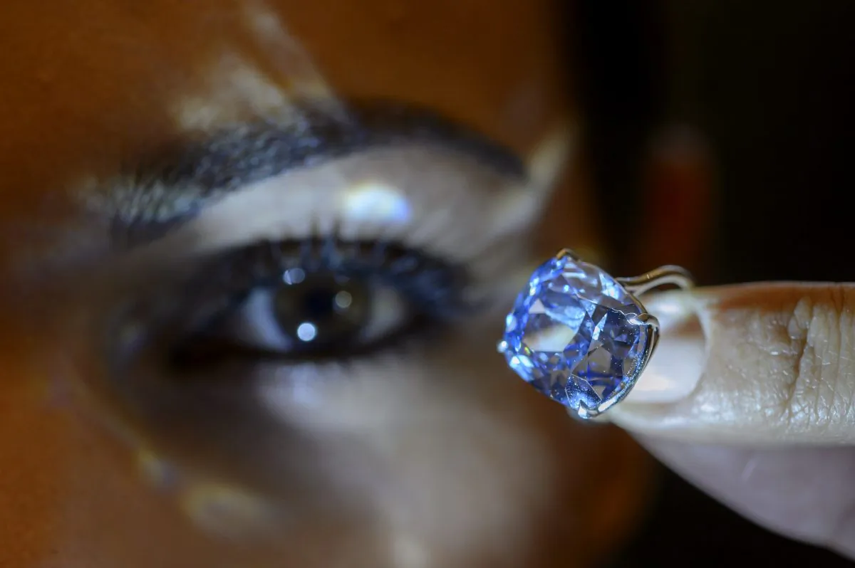 A Sotheby's employee displays the rare Blue Moon Diamond during a preview at Sotheby's, in Geneva, Switzerland, on Nov. 4, 2015. The 12.03 carat blue diamond is the largest cushion shaped fancy vivid blue diamond ever appear at auction. It is estimated to sell between 35 and 55 million U.S. dollars. The auction will take place in Geneva, on Nov. 11, 2015. (Martial Trezzini/Keystone via AP)