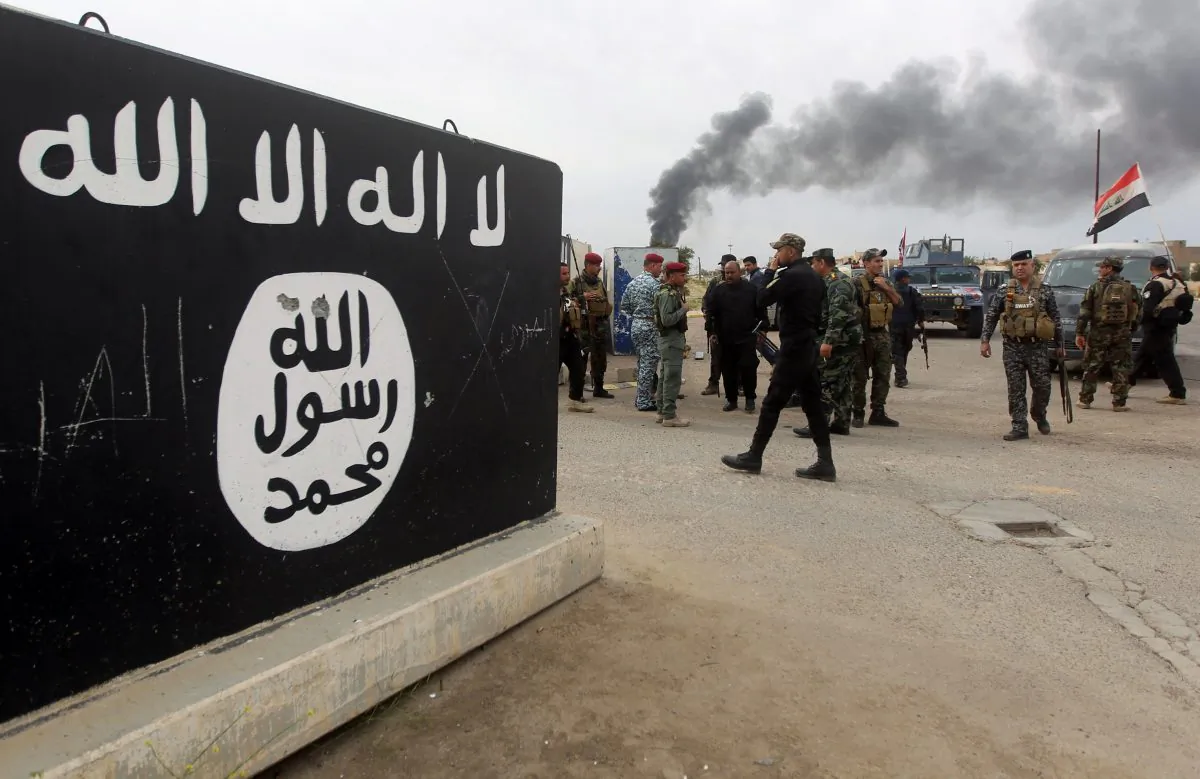 Iraqi security forces and Shiite fighters gather next to a mural showing the emblem of ISIS on April 1 in Tikrit, after retaking the city from ISIS. (Ahmad Al-Rubaye/AFP/Getty Images)