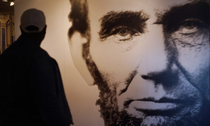 A visitor to an exhibit at the Lincoln Memorial walks past an image of Abraham Lincoln in Washington, D.C., on April 1, 2015. (Mandel Ngan/AFP/Getty Images)