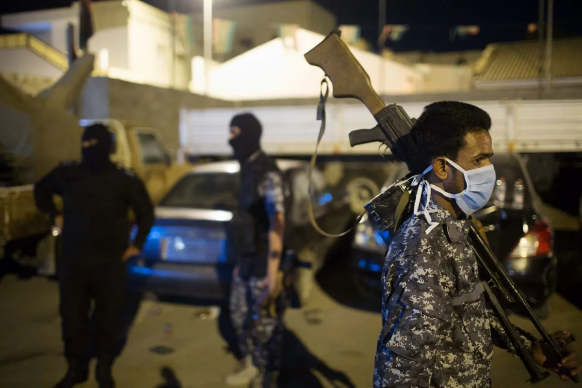 Libyan immigration police gather during a raid on a home holding African migrants on the outskirts of Tripoli, Libya, early Tuesday, Oct. 13, 2015. (AP Photo/Mohamed Ben Khalifa)