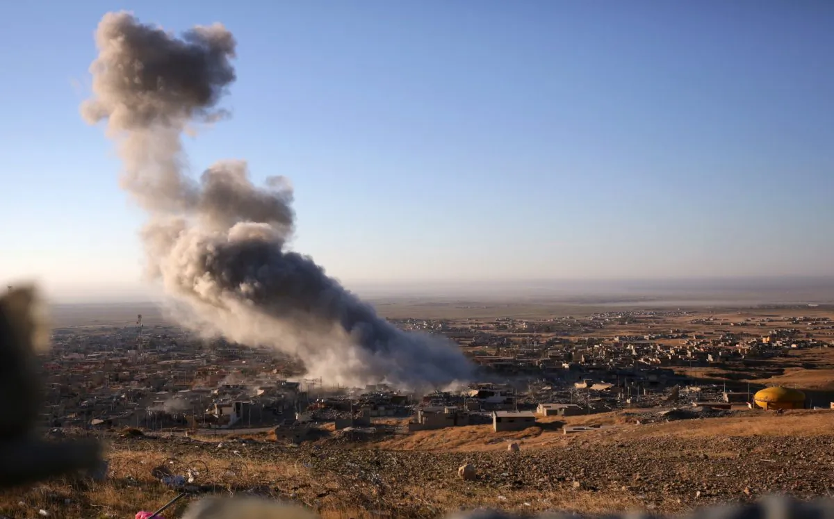 Smoke believed to be from an airstrike billows over the northern Iraqi town of Sinjar on Thursday, Nov. 12, 2015. (AP Photo/Bram Janssen)