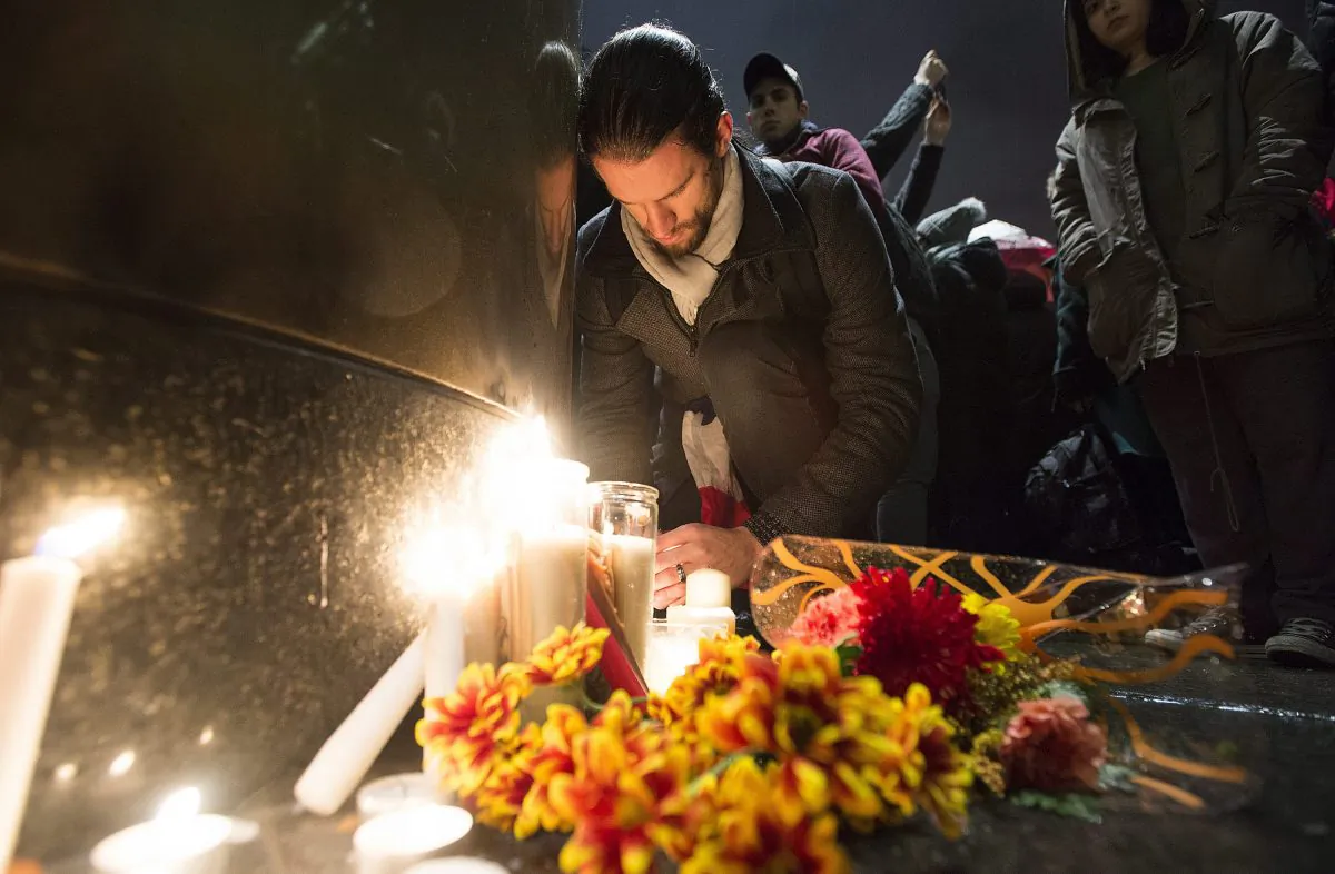 People light candles at a vigil outside the French consulate in Montreal, Friday, Nov. 13, 2015. Canadian Prime Minister Justin Trudeau offered "all of Canada's support" to France on Friday night in the wake of "deeply worrying" terrorist attacks in Paris. (Graham Hughes/The Canadian Press via AP)