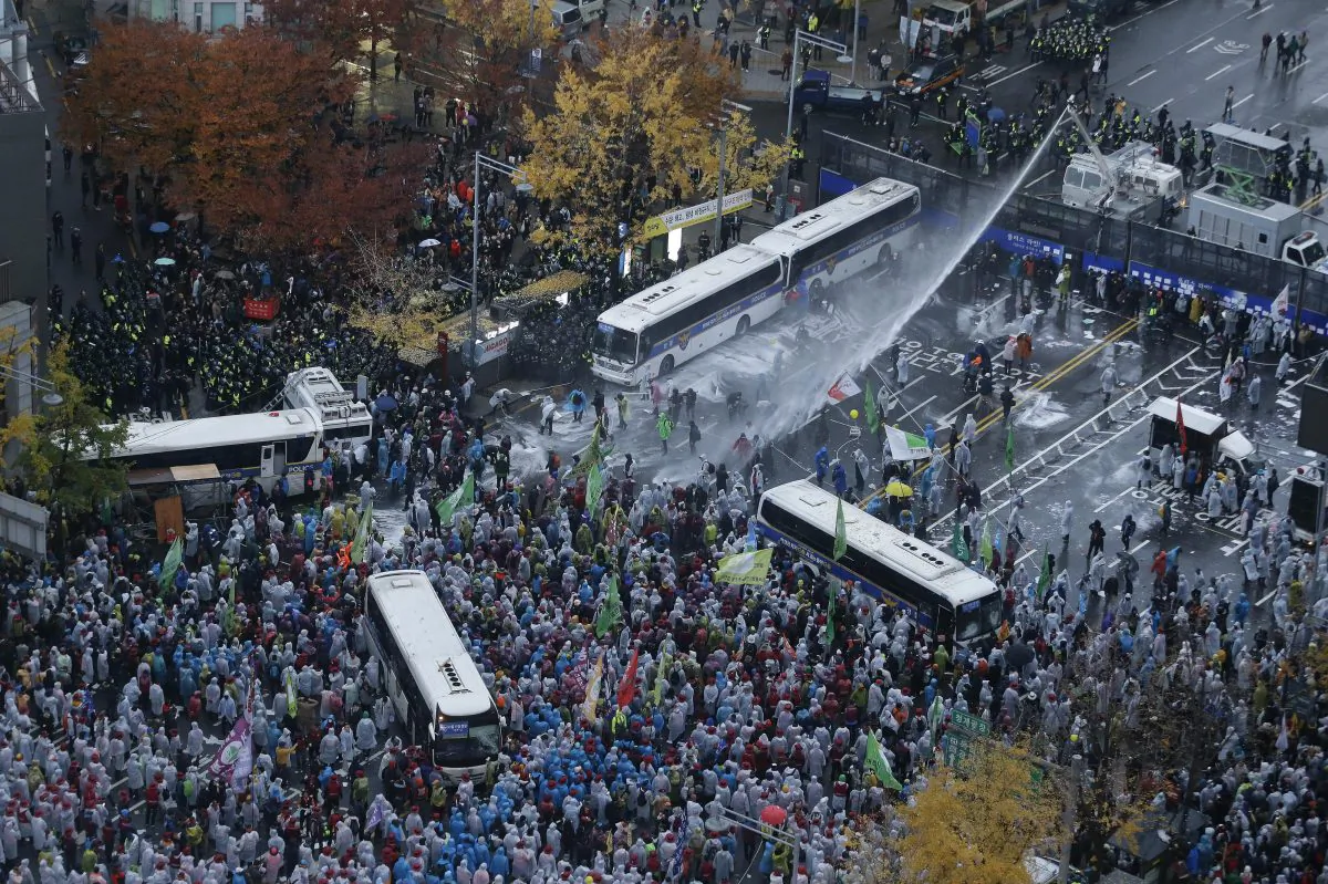 South Korean riot police officers spray a water cannon as police officers try to break up protesters who try to march to the Presidential House after a rally against government policy in Seoul, South Korea, on Nov. 14, 2015. Police fired tear gas and water cannons Saturday as they clashed with anti-government demonstrators who marched through Seoul in what was believed to be the largest protest in South Korea's capital in more than seven years. (AP Photo/Ahn Young-joon)