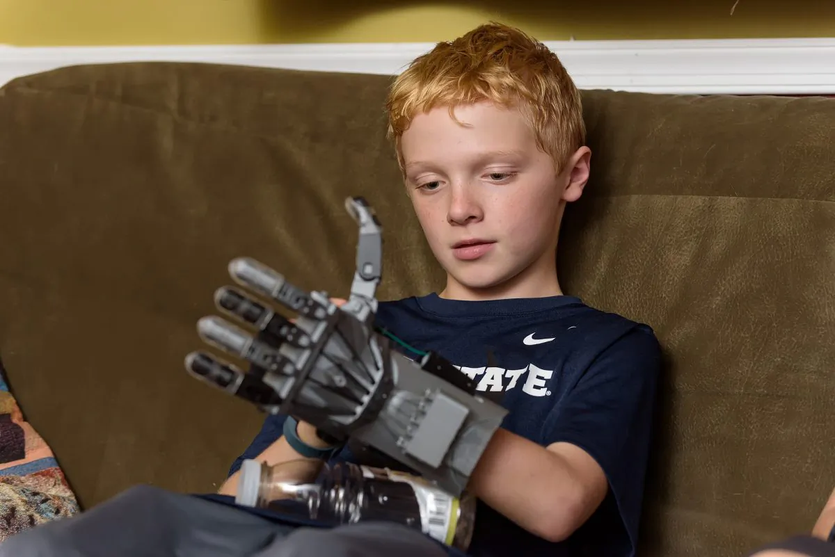 In this Oct. 22, 2015, photo, Colin Consavage, 10, of Claymont, Del., shows the prosthetic hand he made himself with a 3D printer at the local library. Colin was born with his left hand in a fist, the result of amniotic banding that kept one hand stunted. He used a 3-D printer at the Wilmington Public Library to make himself a mechanical replacement. (Doug Curran/The Wilmington News-Journal via AP)