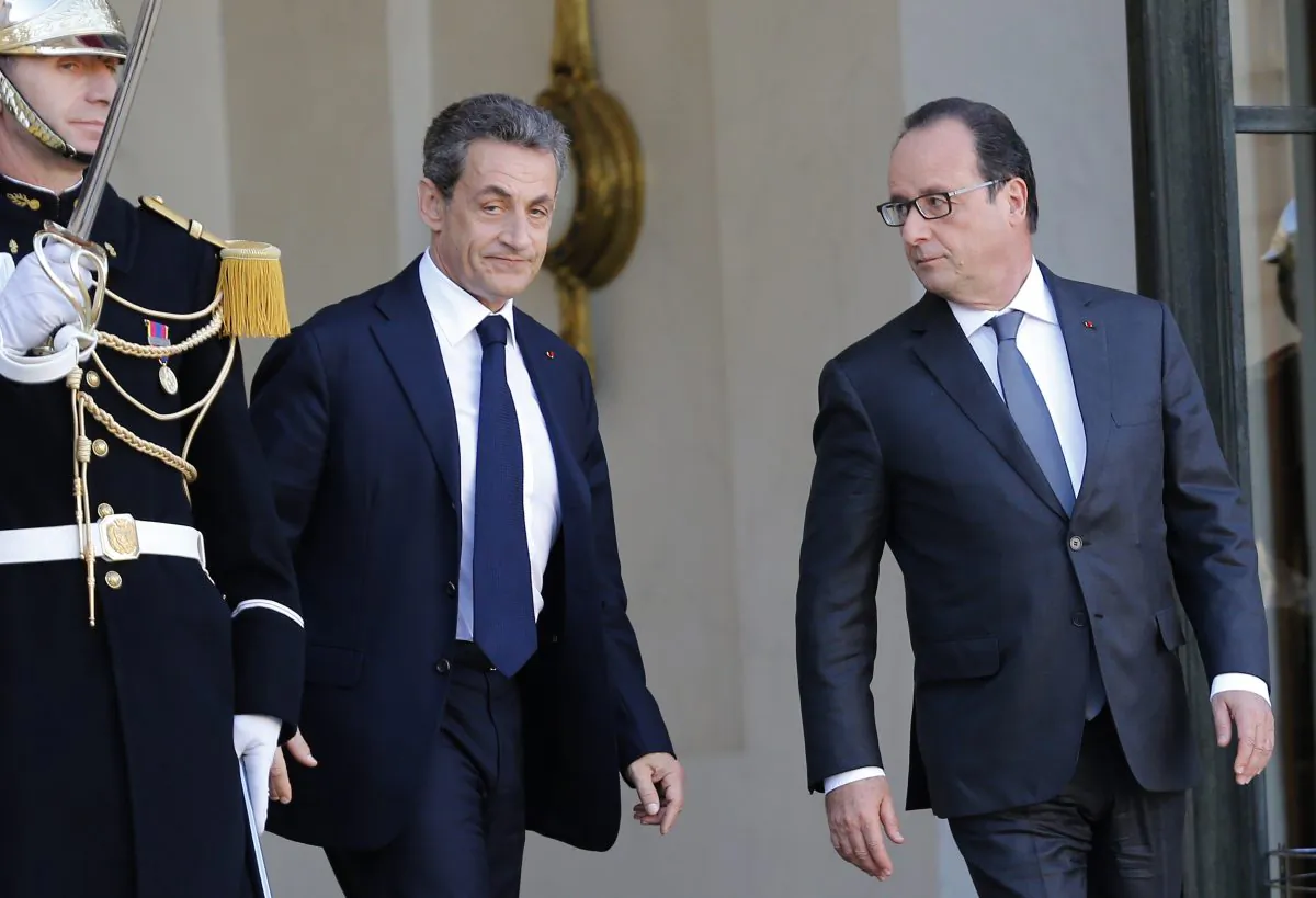 Former French President, Nicolas Sarkozy, leaves the Elysee Palace after a meeting with France's President, Francois Hollande (R) in Paris, Sunday, Nov. 15, 2015. (AP Photo/Jacques Brinon)