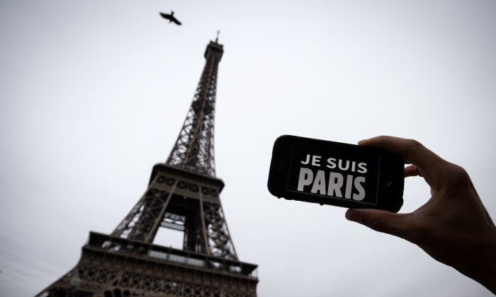 In this illustration picture taken in Paris on November 14, 2015 a person holds aloft a smartphone bearing the message "Je Suis Paris" in front of the Eiffel Tour, following a series of attacks on the city in which at least 128 people were killed.  Islamic State jihadists on Saturday claimed a series of coordinated attacks by gunmen and suicide bombers in Paris that killed at least 128 people in scenes of carnage at a concert hall, restaurants and the national stadium.
 AFP PHOTO / JOEL SAGET        (Photo credit should read JOEL SAGET/AFP/Getty Images)