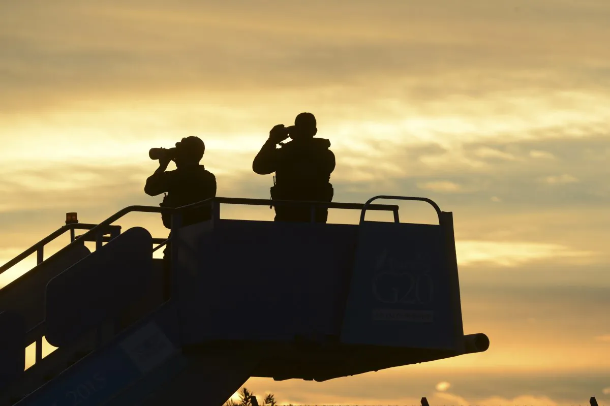 Security officials stand guard as they wait for the plane carrying President Barack Obama to land in Antalya, Turkey, Sunday, Nov. 15, 2015, for the G-20 summit. The 2015 G-20 Leaders Summit is held near the Turkish Mediterranean coastal city of Antalya on Nov. 15-16, 2015. (Ali Atmaca/Anadolu Agency via AP)