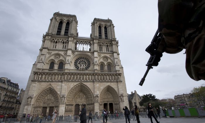 A soldier patrols at Notre Dame Cathedral in Paris, Monday, Nov. 16, 2015. France is urging its European partners to move swiftly to boost intelligence sharing, fight arms trafficking and terror financing, and strengthen border security in the wake of the Paris attacks. (AP Photo/Peter Dejong)