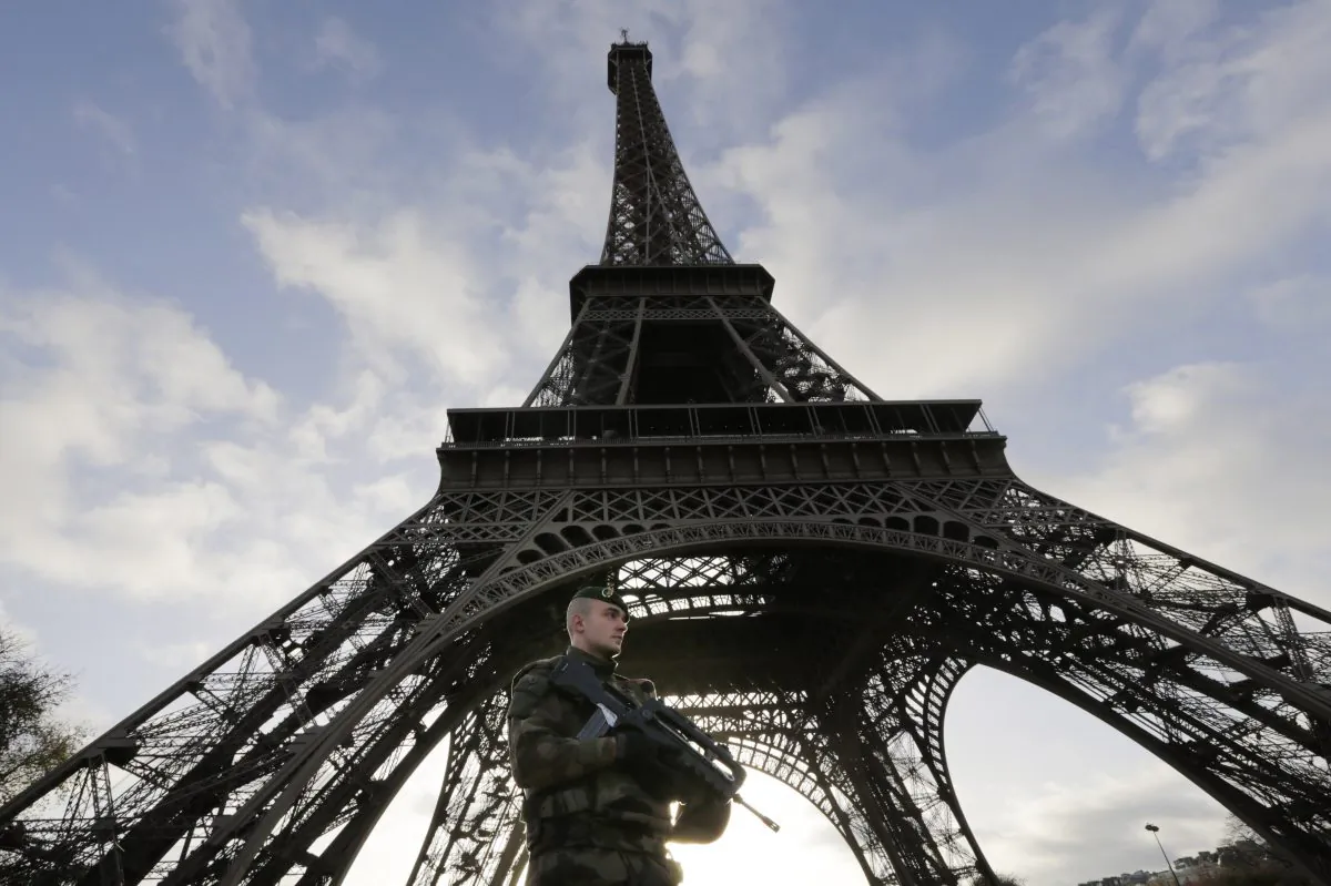 A French soldier stands alert at the Eiffel Tower which remained closed on the first of three days of national mourning in Paris, Sunday, Nov. 15, 2015. Thousands of French troops deployed around Paris on Sunday and tourist sites stood shuttered in one of the most visited cities on Earth while investigators questioned the relatives of a suspected suicide bomber involved in the country's deadliest violence since World War II. (AP Photo/Amr Nabil)