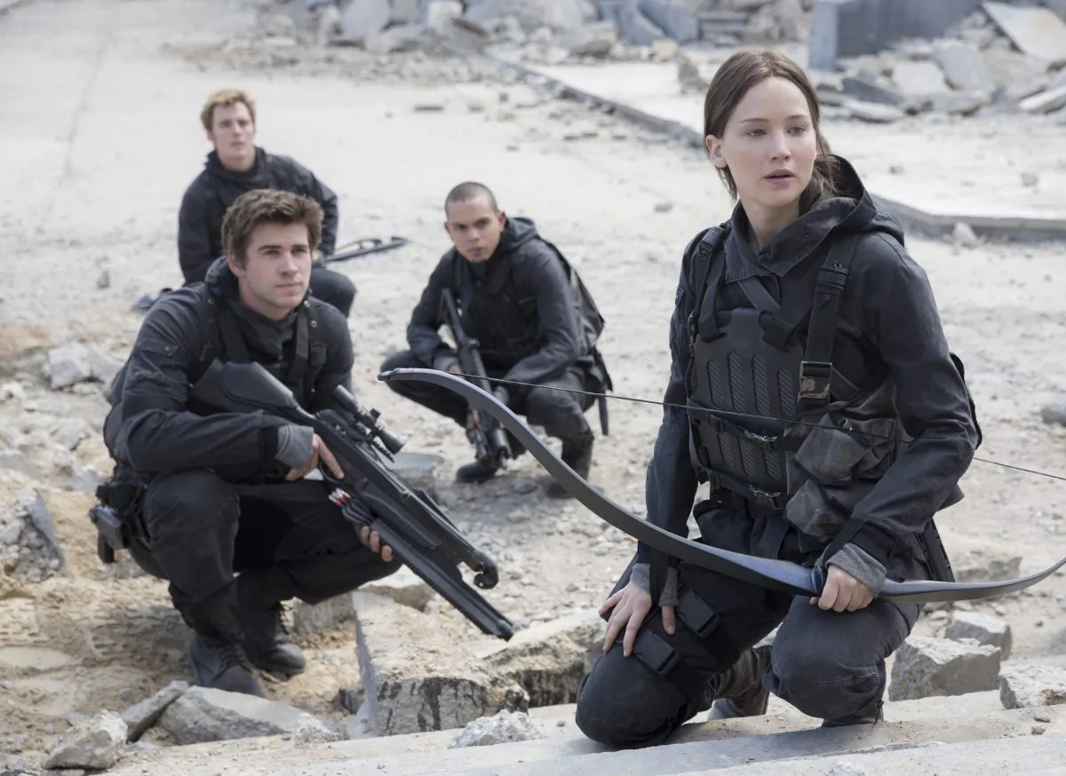 This photo provided by Lionsgate shows, Liam Hemsworth, left, as Gale Hawthorne, Sam Clafin, back left, as Finnick Odair, Evan Ross, back right, as Messalia, and Jennifer Lawrence, right, as Katniss Everdeen, in the film, "The Hunger Games: Mockingjay - Part 2." The movie opens in U.S. theaters on Nov. 20, 2015. (Murray Close/Lionsgate via AP)