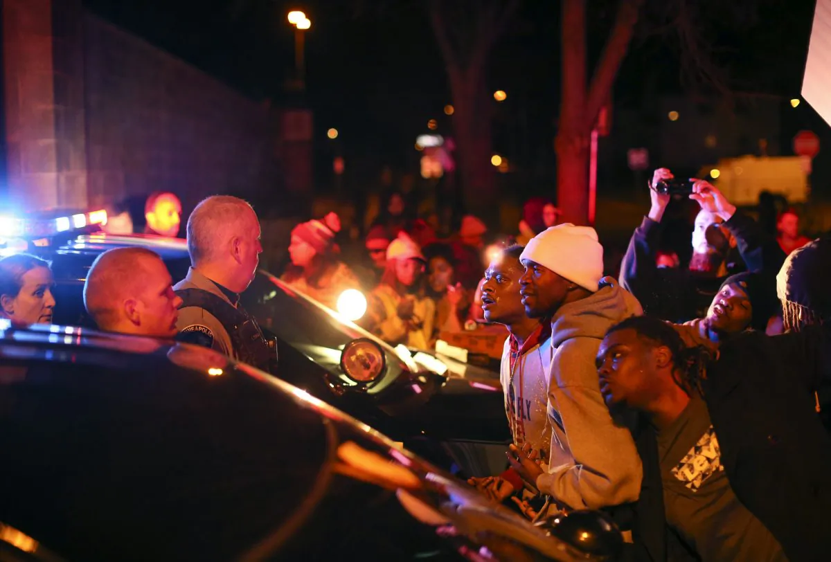 Demonstrators chanted at Minneapolis police officers at the side entrance to the 4th Precinct station on Morgan Ave. N. Sunday, Nov. 15, 2015, in Minneapolis, after a man was shot by Minneapolis police early Sunday morning, Black Lives Matters and others protested Sunday night. (Jeff Wheeler/Star Tribune via AP)