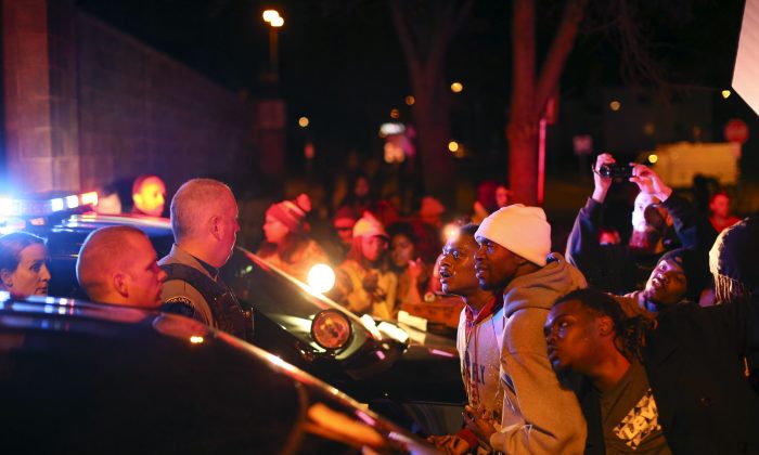 Demonstrators chanted at Minneapolis police officers at the side entrance to the 4th Precinct station on Morgan Ave. N.  Sunday, Nov. 15, 2015, in Minneapolis, after a man was shot by Minneapolis police early Sunday morning, Black Lives Matters and others protested Sunday night. (Jeff Wheeler/Star Tribune via AP)