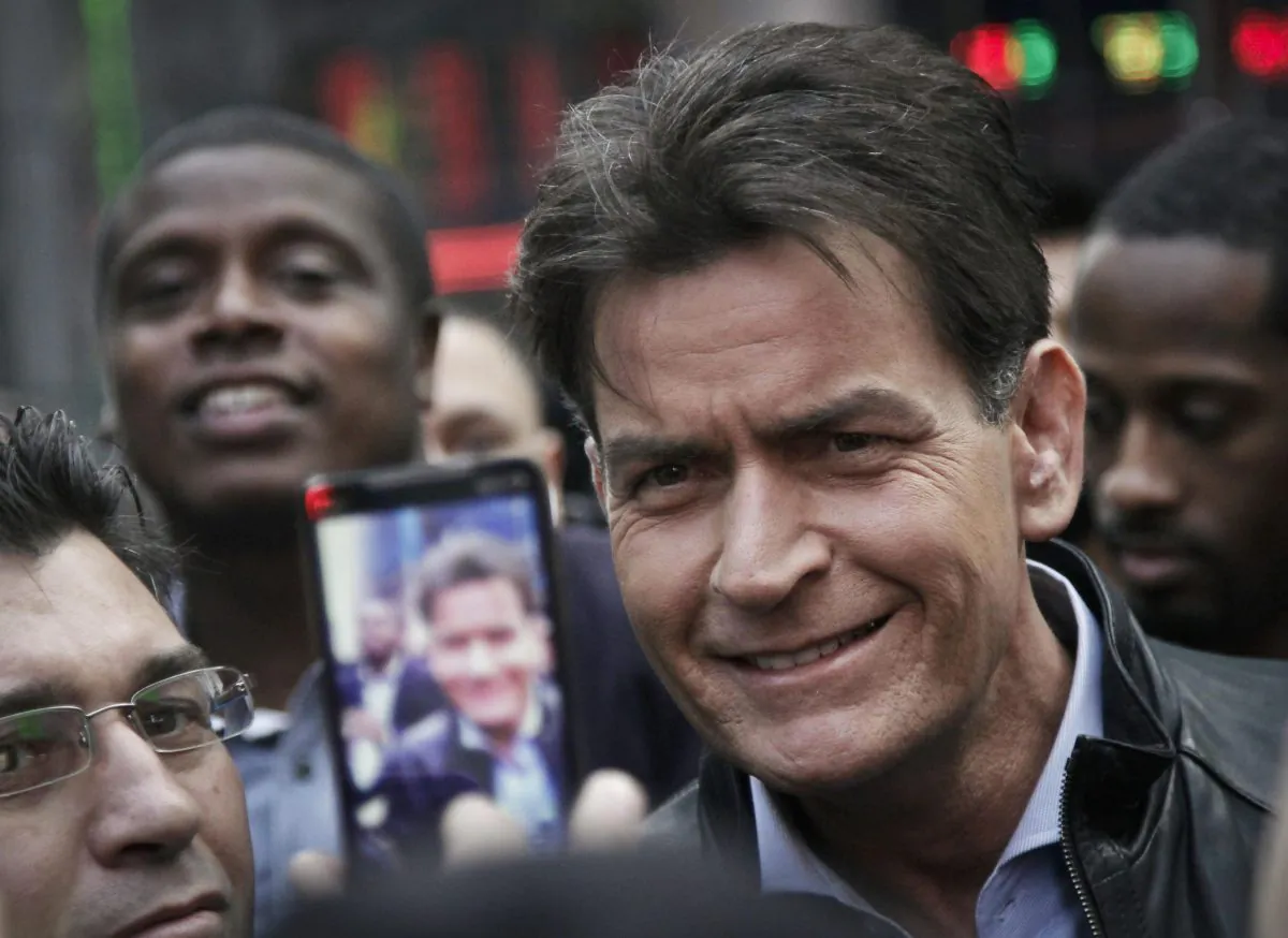 Actor Charlie Sheen is mobbed for autographs and photos as he makes his way through Times Square in New York on Jan. 14, 2013. In an interview Tuesday, Nov. 17, 2015, on NBC's "Today," Sheen said he tested positive for the virus that causes AIDS. (AP Photo/Bebeto Matthews)