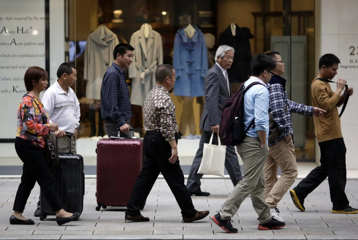 Foreign shoppers walk at a shopping district in Tokyo, Tuesday, Nov. 17, 2015. Japan, the world’s third-largest economy, is highly dependent on the health of other economies, such as the U.S. and China, to keep growth going because much of the Japanese economy is export-led. One concern is that China’s growth is gradually slowing. (AP Photo/Eugene Hoshiko)