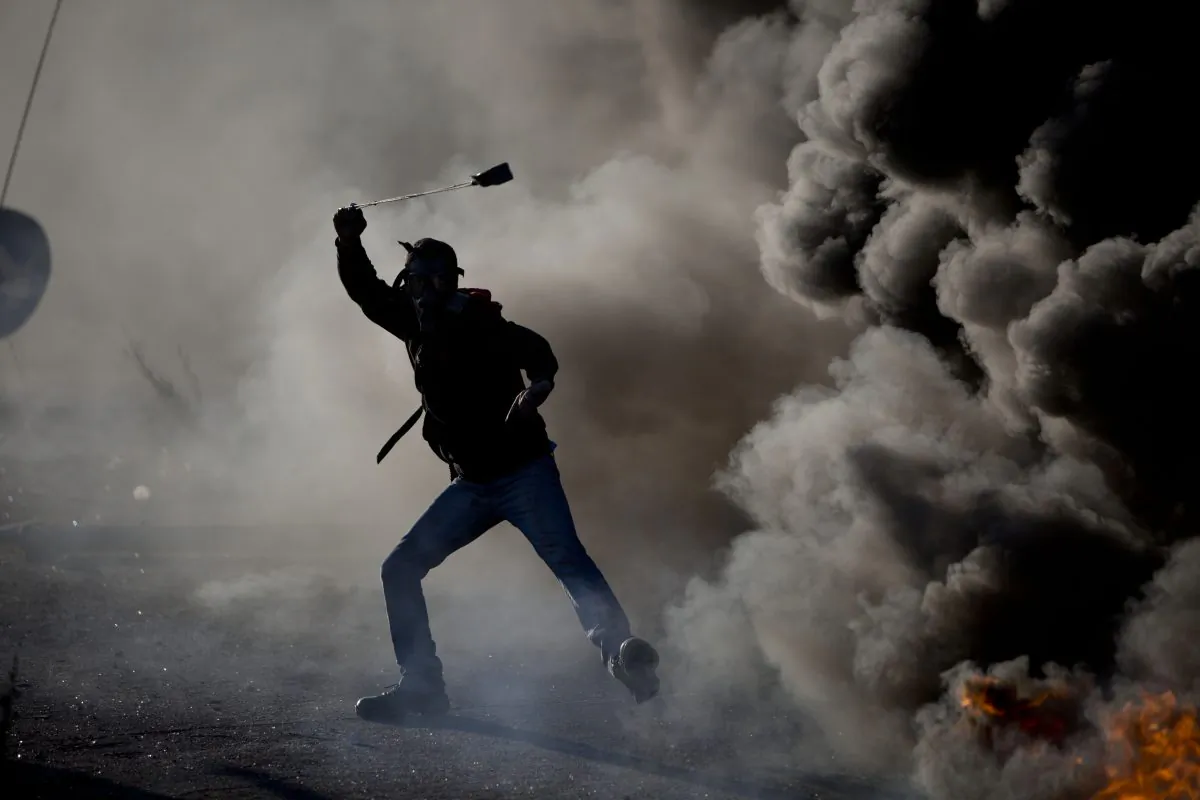A Palestinian swings a sling during clashes with Israeli troops, in the West Bank city of Ramallah, on Nov. 13, 2015. (AP Photo/Majdi Mohammed)